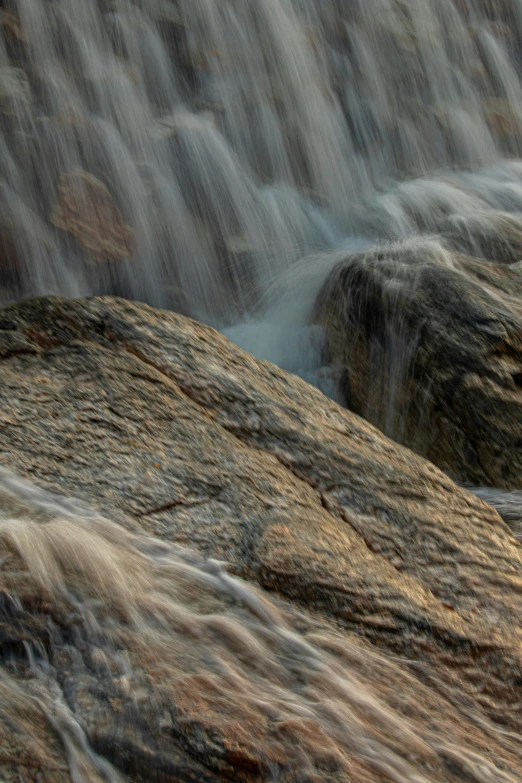 a waterfall coming down from the side of a rock formation