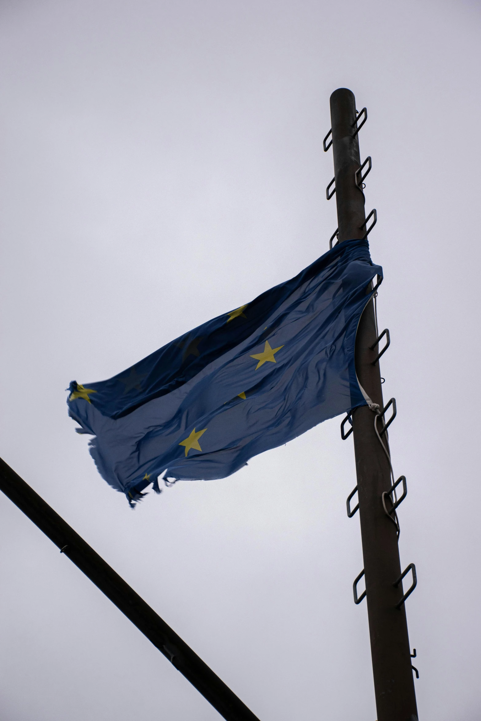 a flag flying on a post with the sky in the background