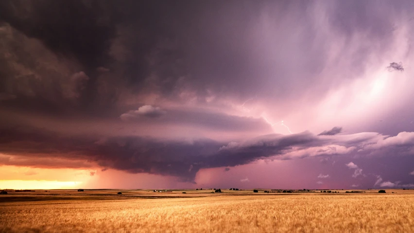 the view of a prairie looking out at a storm that is approaching