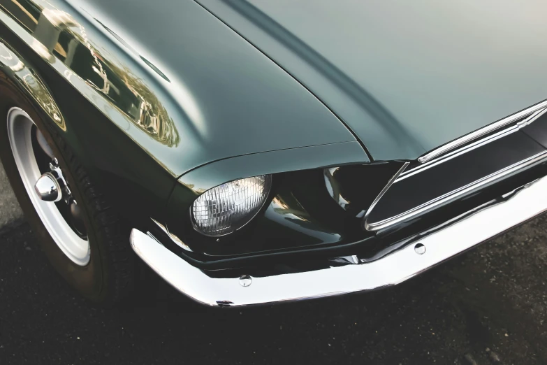 the front end of a black mustang muscle car