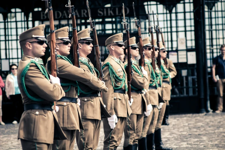 a line of men wearing uniform marching down the street