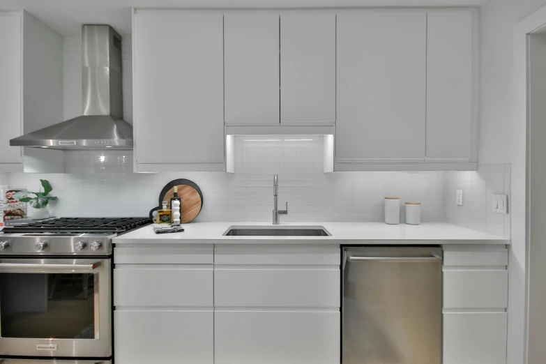 a kitchen with white cabinets and white counters