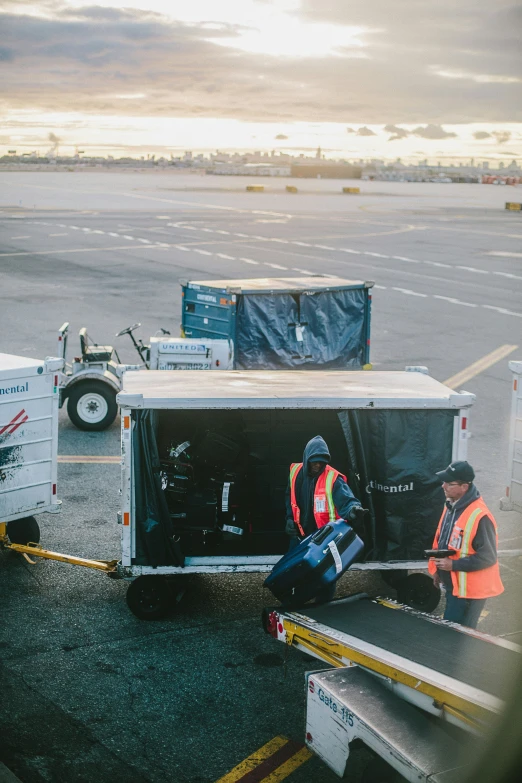 two people carrying baggage on the tarmac of an airport