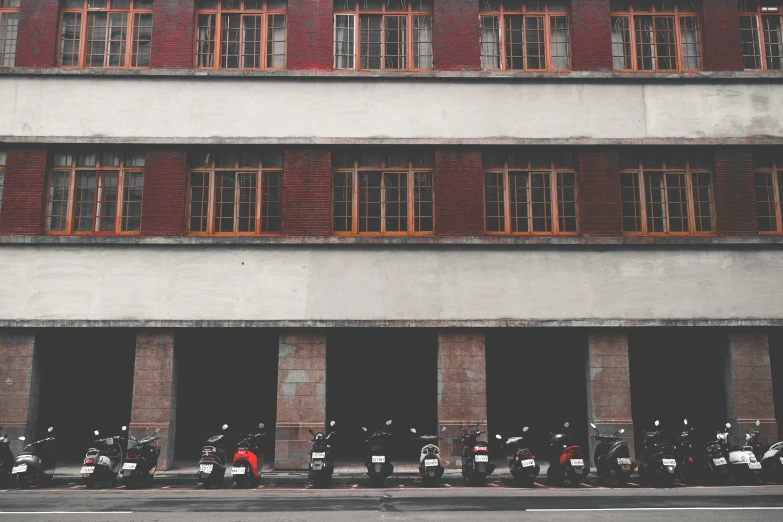 the motor bikes are parked in front of the buildings