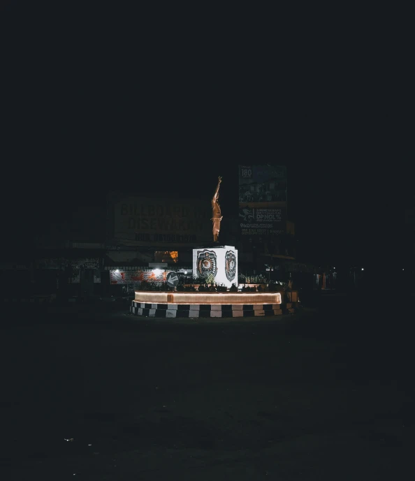 two white square benches and some buildings on a dark night