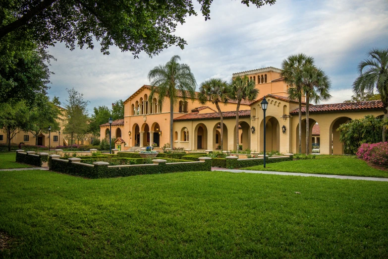 a building with a green yard and trees