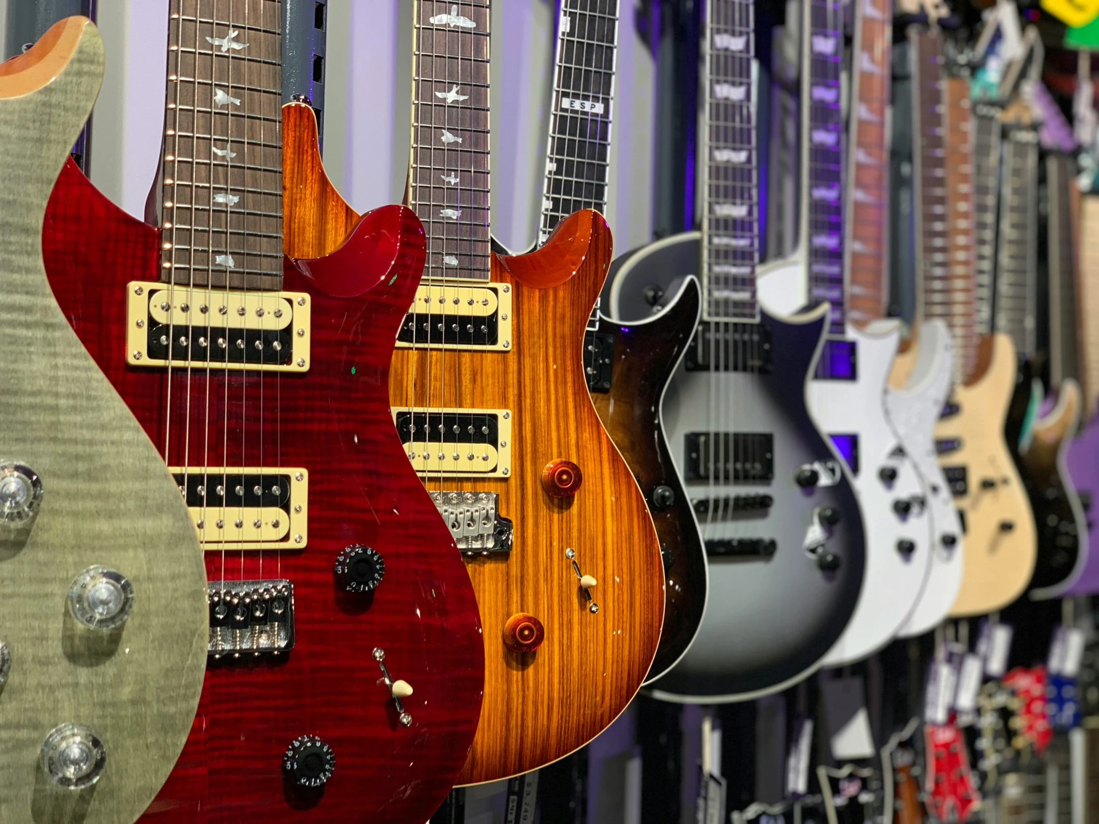 a bunch of guitars that are all lined up