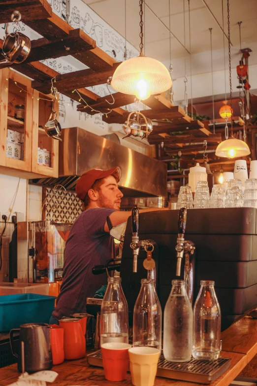 a man behind a bar filled with glass bottles