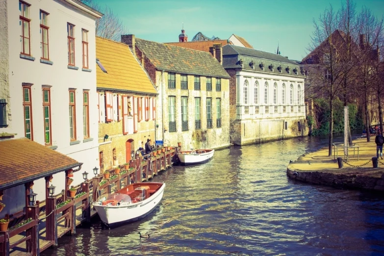 there are boats docked at a wharf that has houses along it