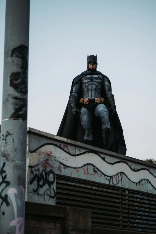 a person sits on top of a graffiti covered building