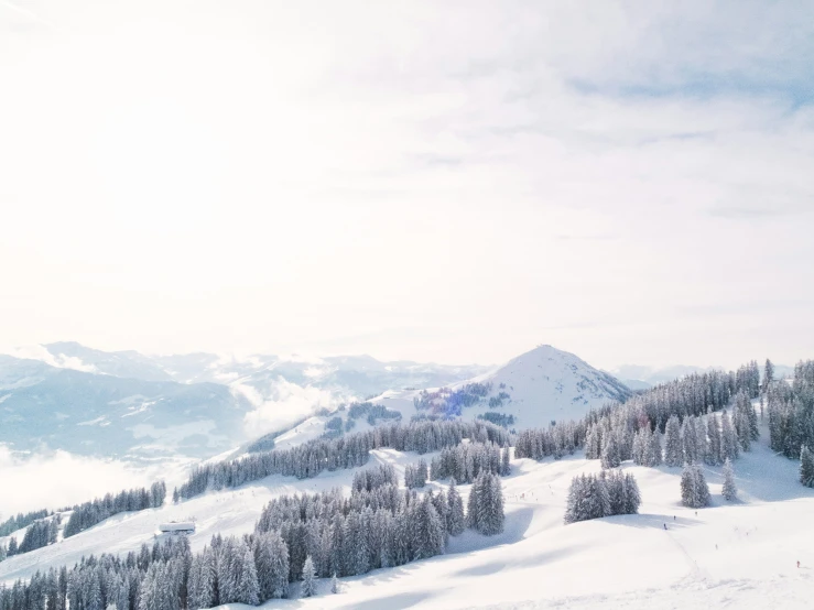 a lone skier on the slopes with mountains in the background