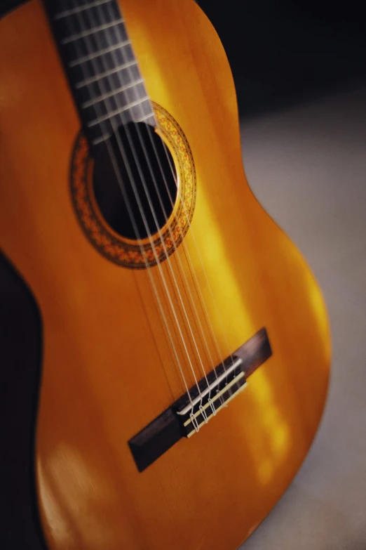 a close up of a brown guitar hanging on a wall