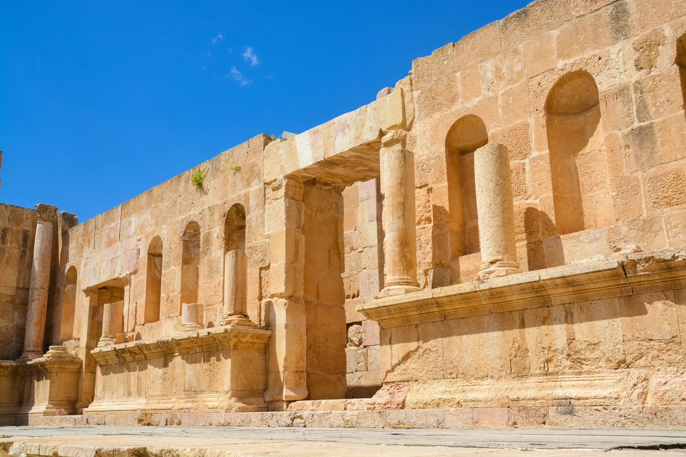 an ancient building with two towers, pillars and windows