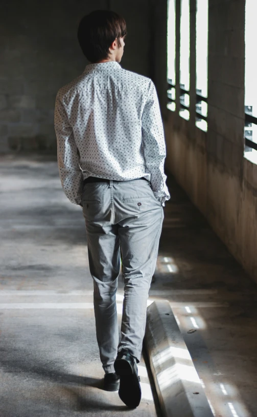 a person wearing grey pants and a white shirt