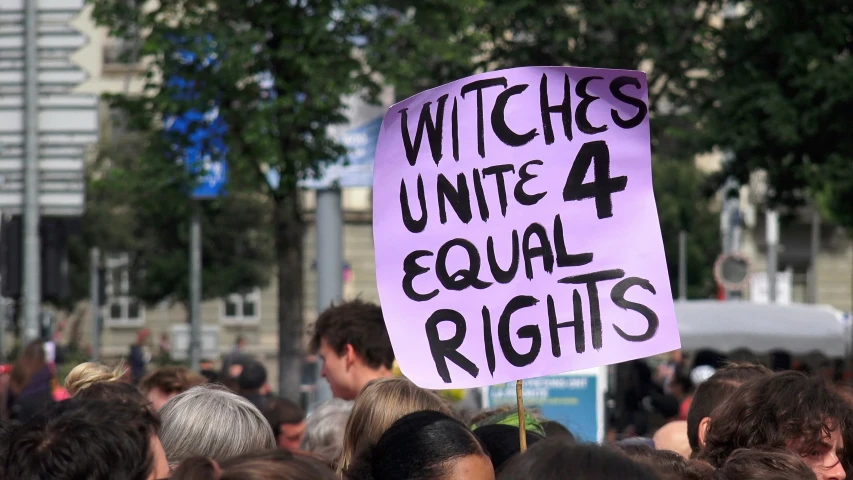 a sign at an occupy protest with the words witches united and equal rights on it