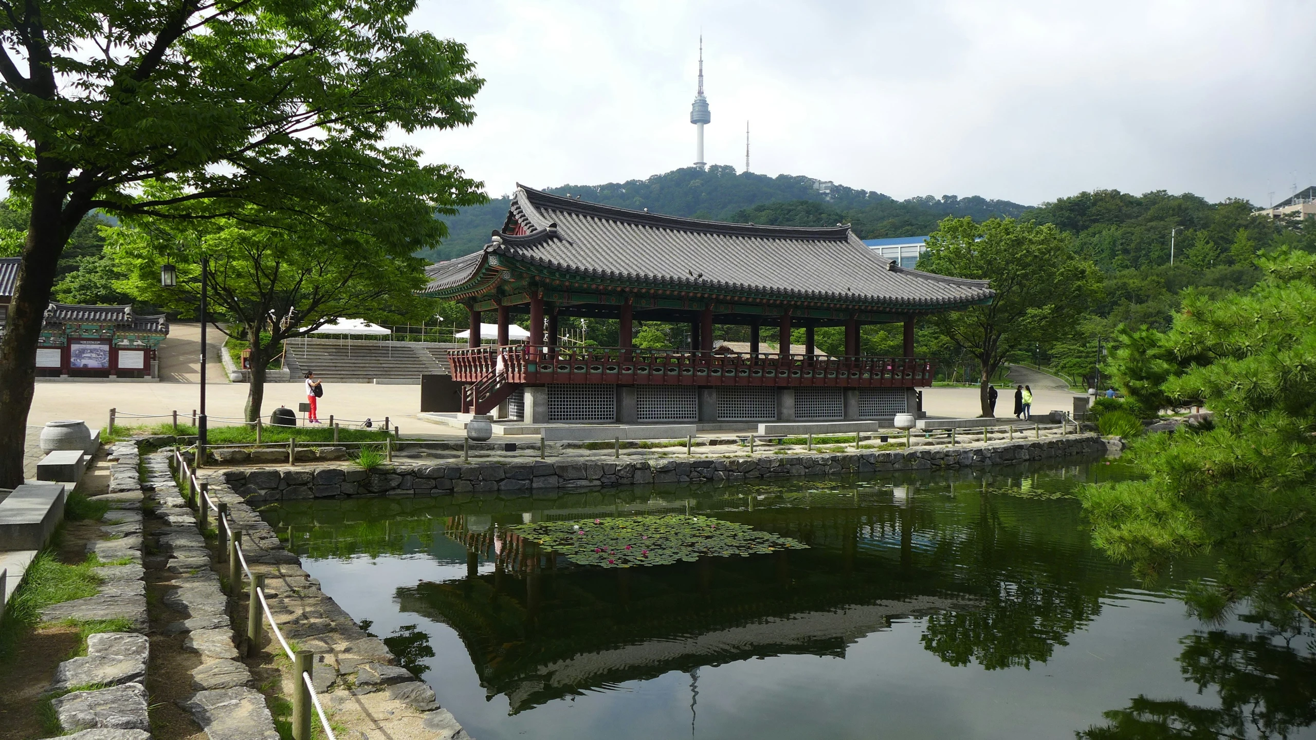 a pavilion sitting on a lake near trees