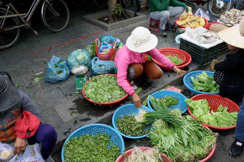 women preparing food from baskets outside on the street