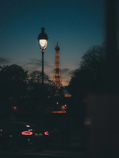 cars passing by the eiffel tower at night
