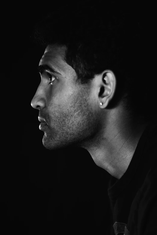 a man with very dark hair looking down