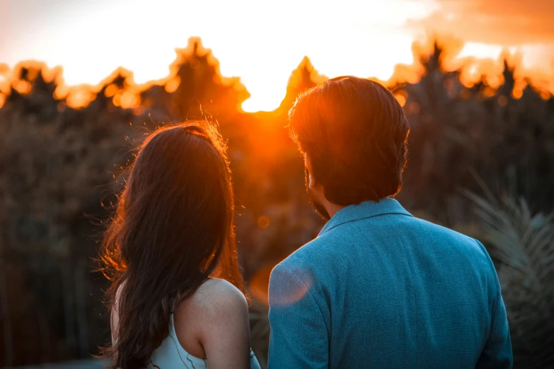 a couple is looking at the setting sun