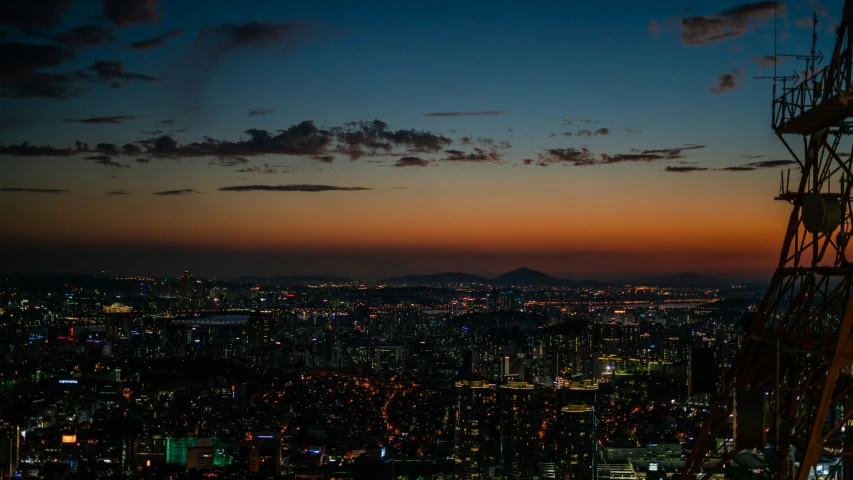 a city lit up at dusk with the moon rising