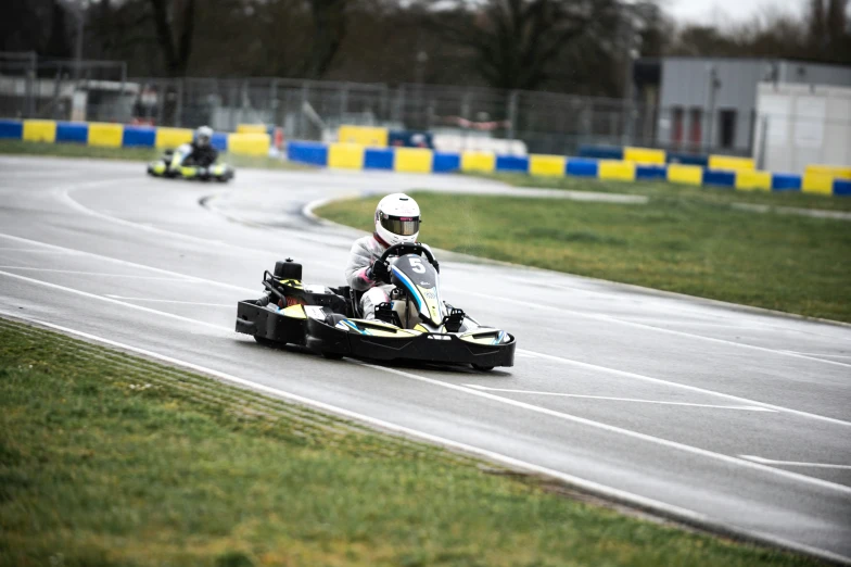 three men racing carts down a race track