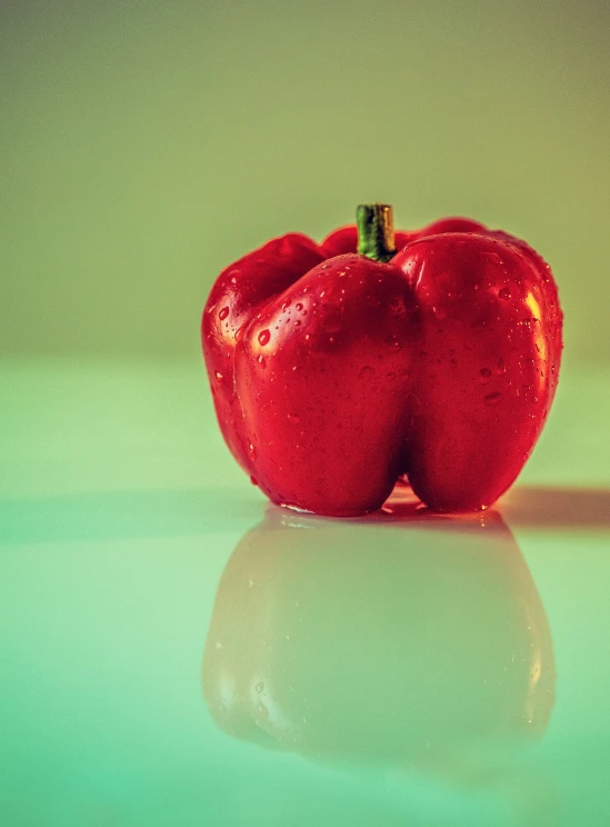 a red pepper sitting on top of a glass table