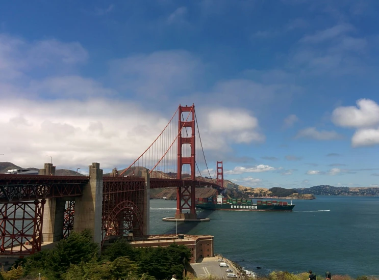 a large boat travels near a bridge in the ocean