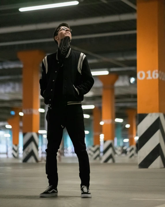 a man standing in a parking garage while leaning his head into the air