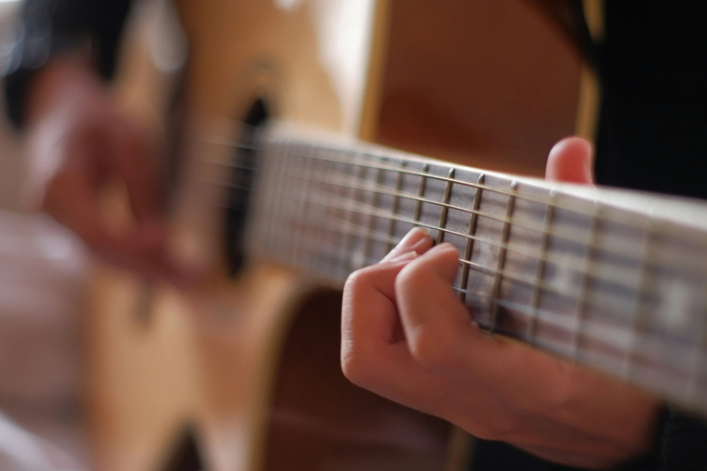 a person is playing an acoustic guitar close up