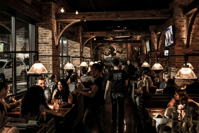 a group of people sit inside a restaurant while people watch