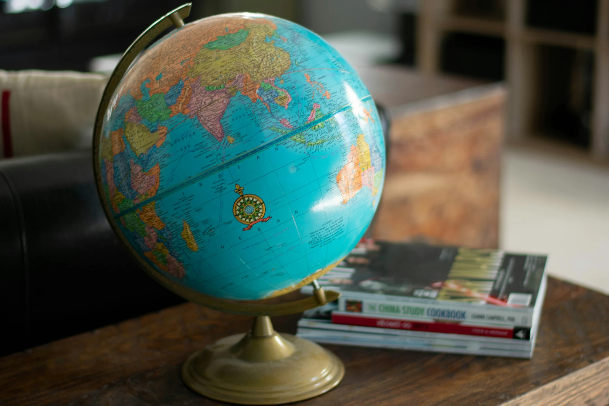 an antique, blue globe sitting on a table near a stack of books