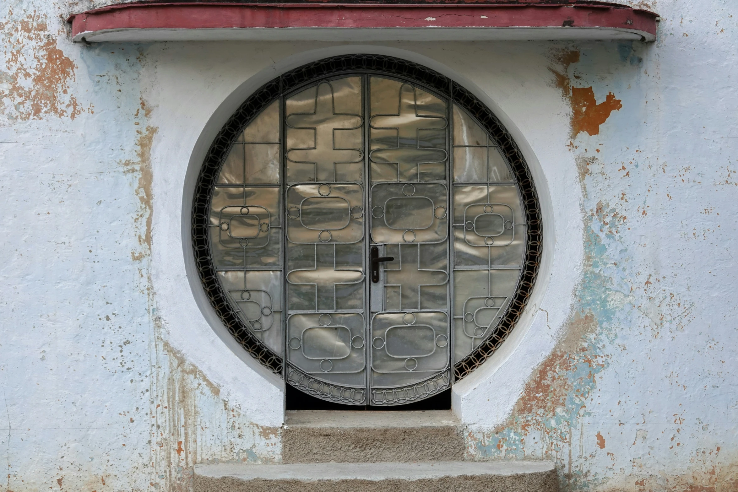 a door to an old white building has round window panes