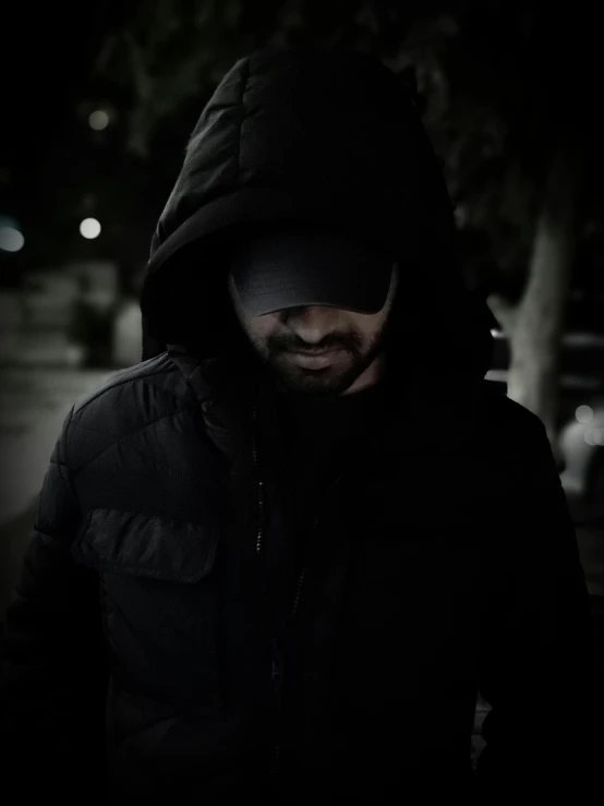 a man standing on a sidewalk in the dark