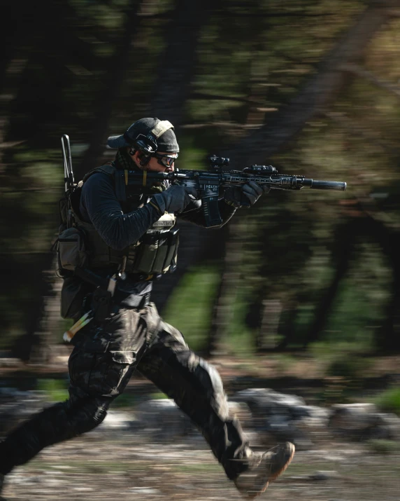 a soldier with a machine gun runs through the forest