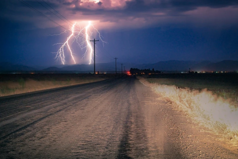 a big cloud filled with lightning and a car