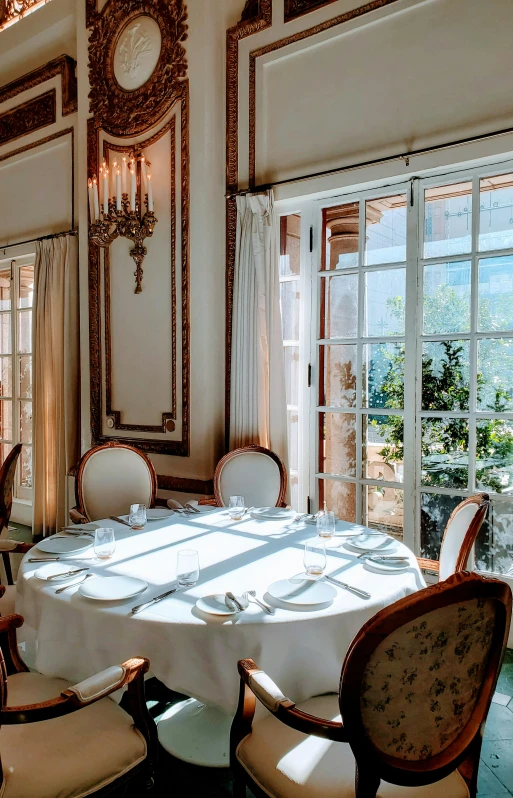 an elegant restaurant with windows, chairs and tables