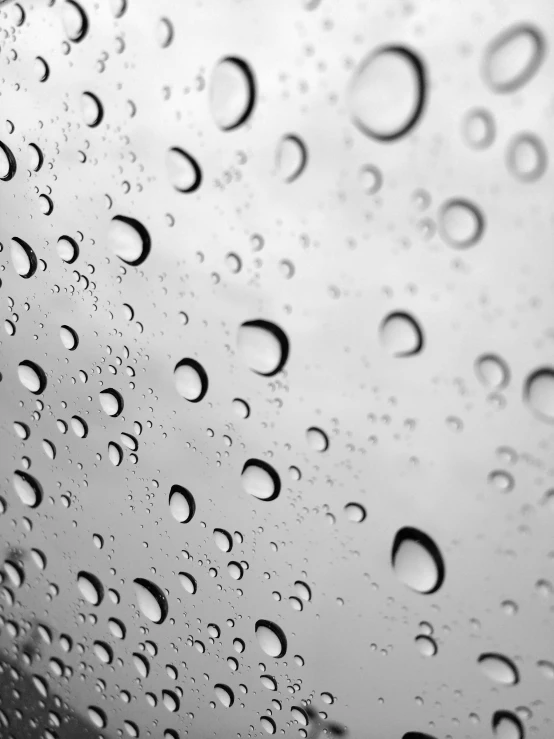 a black and white image of raindrops on the window