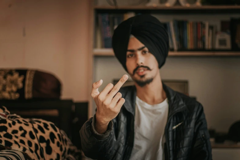 a man with a turban gives the peace sign