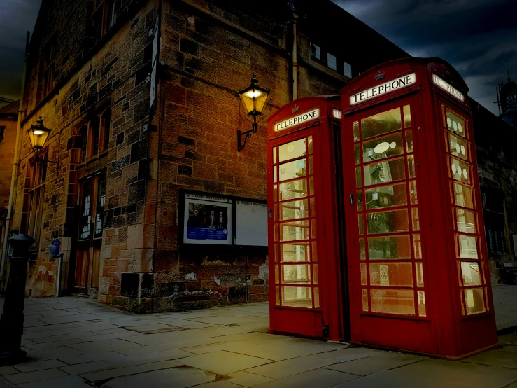 two red phone booths on a city sidewalk