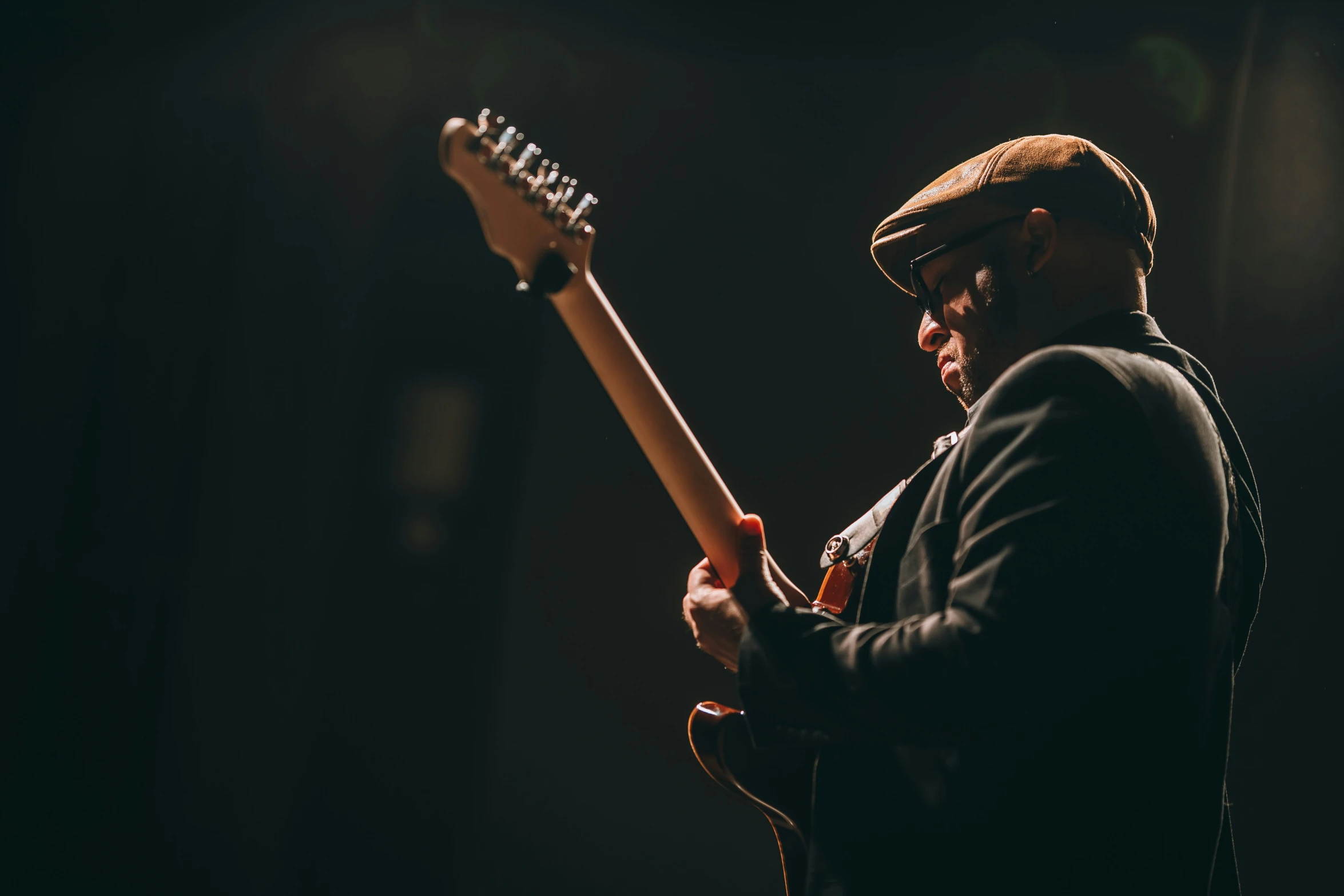 a man holding a large guitar over his shoulder