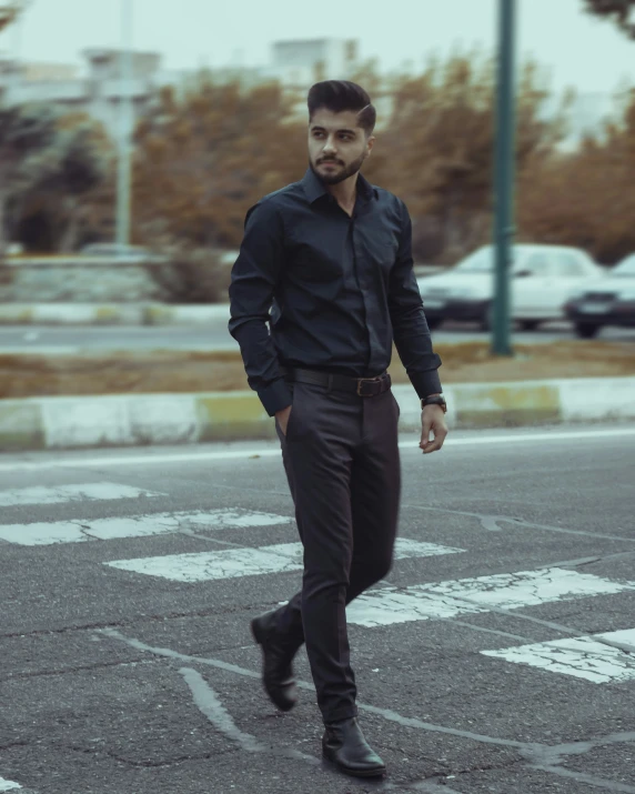 a man in black is standing by the cross walk