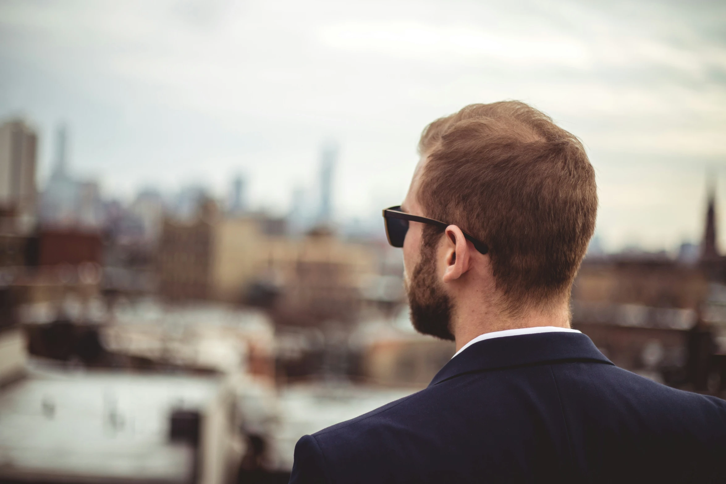 a man with a bald head looks over a large city