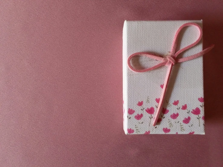 a pink cloth wrapped in a white wrapper with a pink ribbon