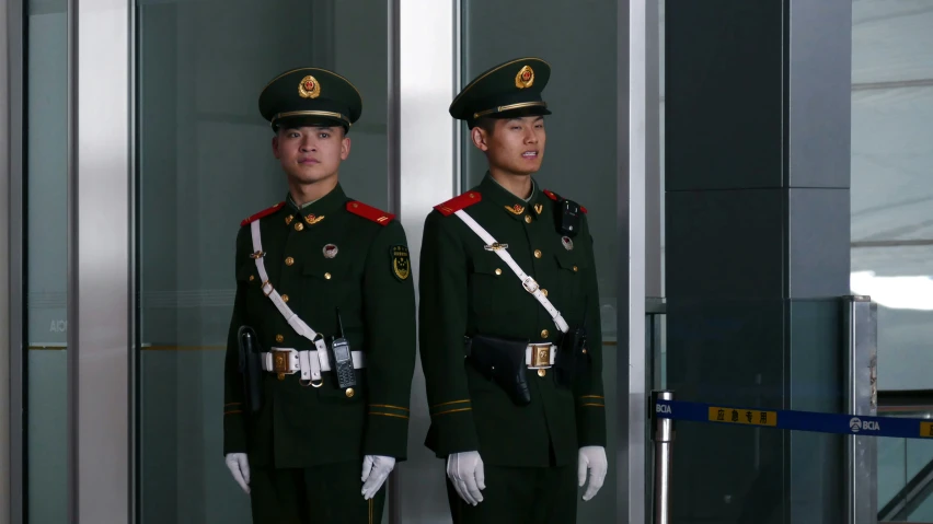 two military men in uniform standing outside a building