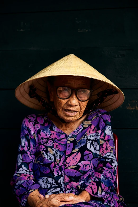 an older asian woman wearing a large hat