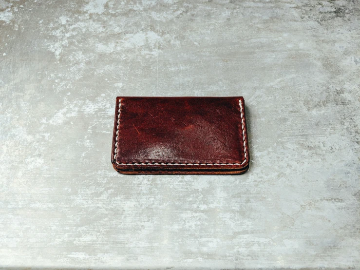 the brown wallet is lying on a white surface