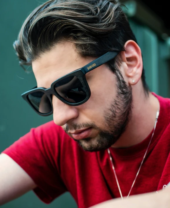 a man with a beard wearing sunglasses looking away