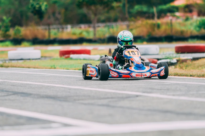 a person is riding a toy racing car on the pavement