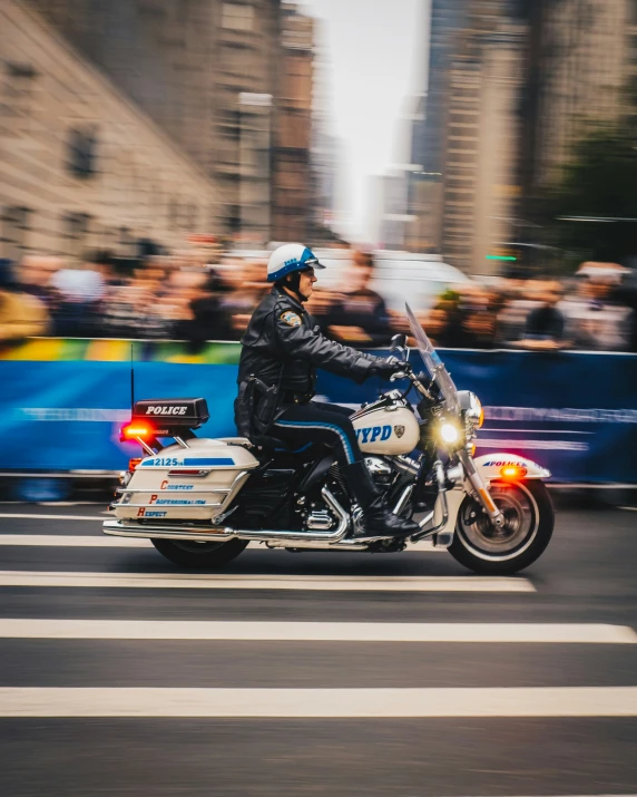 a motorcycle cop is on the street as people look on